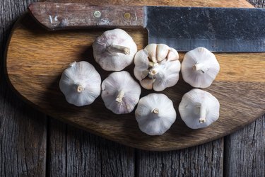 Garlic on wooden chopping board.