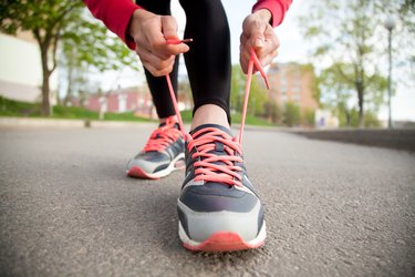 Female hands lacing running shoes. Closeup