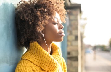 Black woman relaxing listening to guided meditation outside