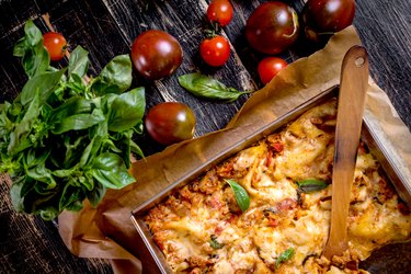 Close-up of a italian lasagna with tomatoes and basil on the table