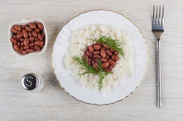 Red beans with rice in plate, salt, fork on table