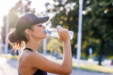 Photo of Sporty young woman drinking water