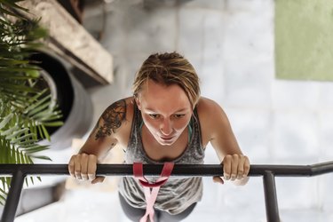 High angle view of woman doing pull-ups at gym