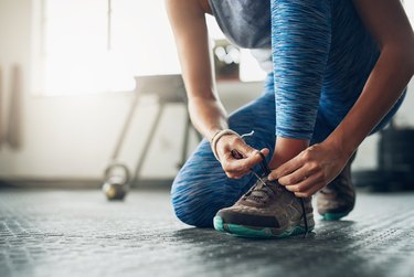 A person tying their sneakers before a workout