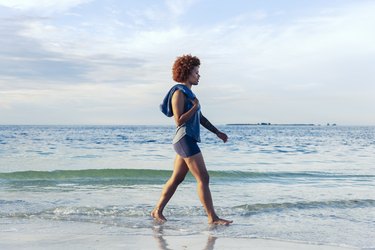 young female walks along beach