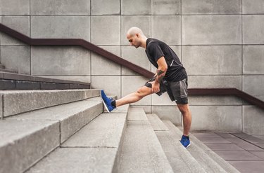 Man Stretching hamstring on stairs With Achilles Tendon Pain