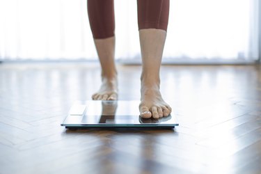 Young woman on home scales