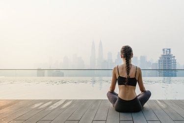 Woman in yoga clothes meditating outside