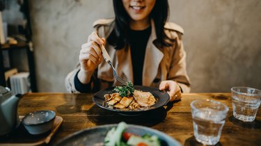 Smiling young woman enjoying dinner date with friends in a restaurant
