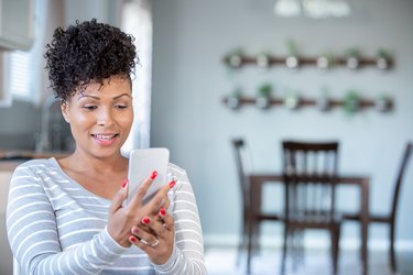 woman uses smartphone for telemedicine appointment with doctor at home