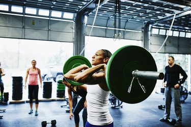 Woman preparing to press barbell overhead