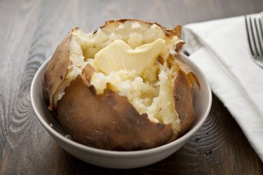 Niacin-rich baked potato sits in a bowl with a dollop of melting butter on top