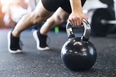 man in gym doing push-ups in a kettlebell workout