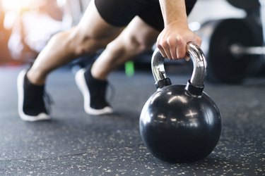 男人在健身房做俯卧撑kettlebell锻炼