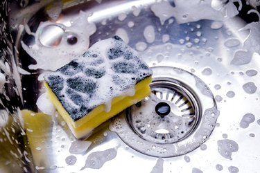 Close view of a sponge full of soap in a kitchen sink