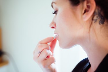 Portrait of a woman taking a pill.