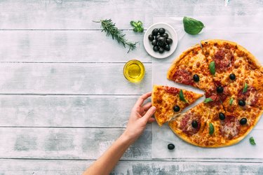 colorful tasty pizza. woman taking piece of italian pizza