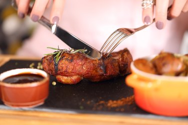 woman eating steak in a restaurant