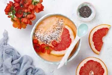 Healthy breakfast set. Superfoods smoothie bowl with chia seeds, coconut, grapefruit and quince flowers. Overhead, top view, flat lay