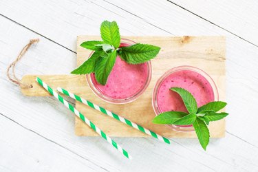 Two glasses of berry smoothies on the white wooden table