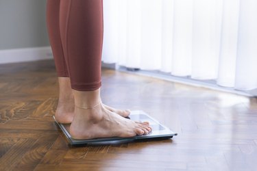 Young woman on home scales