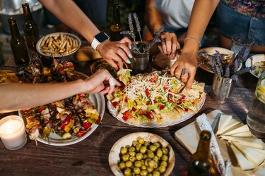 Close-up of friends eating during an outdoor dinner