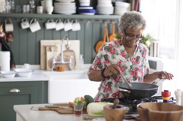 Active senior woman cooking in kitchen