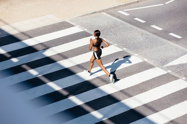 Young woman running on zebra crossing