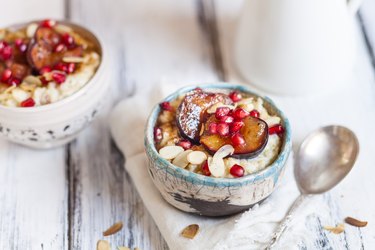 Porridge with cinnamon, millet, backed plum, pomegranate and roasted almond slivers