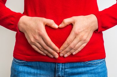 Female hands showing sign of heart on red