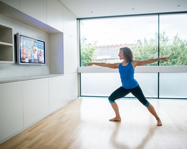 Woman exercising at home watching a workout video
