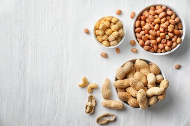 Flat lay composition with different kinds of nuts on light background