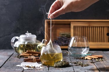 Woman Preparing Herbal Tea On Table