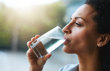 woman drinking water, as a natural remedy for upset stomach