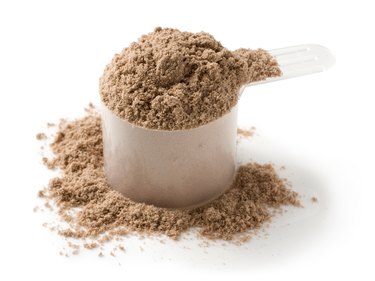 Measuring scoop of protein powder on a white background