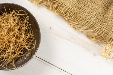 Raw thin noodles on grey wood