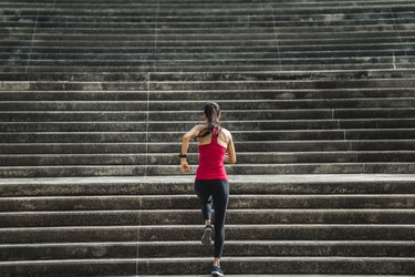 Fitness woman is running up the stairs.