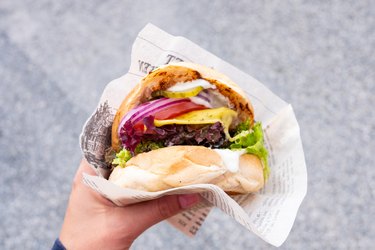 Cropped Hand Of Person Holding Burger