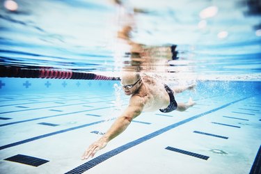 Underwater view of mature male athlete swimming during morning workout