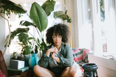 Young woman meditating at home