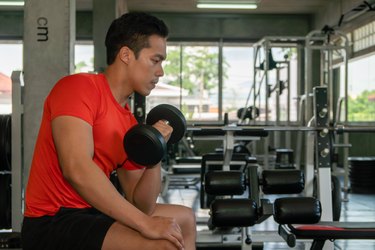male having exercise lifting dumbbell in gym