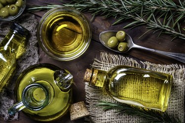 Top view of olives and olive oil bottles on table in a rustic kitchen