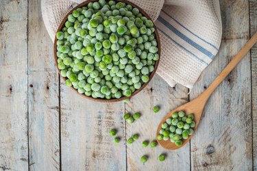 Frozen peas on a wooden table