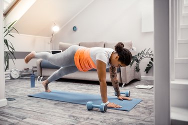 Strong African American woman standing in plank