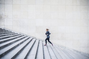 Caucasian woman running up staircase