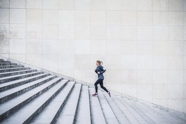 a young adult runs up a stone staircase outside