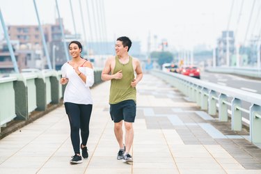 Multi-ethnic couple running together in city