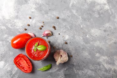 Tasty tomato juice with fresh spices, garlic, pepper and basil.