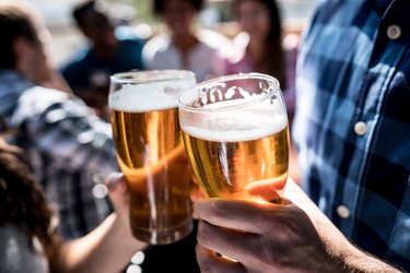 Close up of hands holding a beer and making a toast