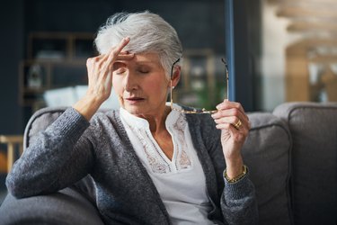senior woman at home suffering from dizziness and blurred vision due to low blood pressure